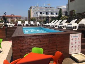 a swimming pool on a rooftop with chairs and a table at Sunrise Hotel Cameria in Durrës
