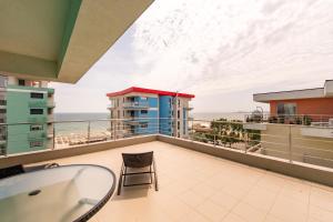 een balkon met een tafel en een stoel en de oceaan bij Summerland Sunrise Apartments in Mamaia