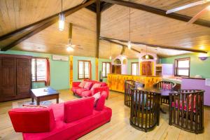 Bananarama Dive & Beach Resort في ويست باي: غرفة معيشة كبيرة مع كنب احمر وطاولة