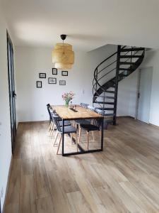 een eetkamer met een tafel en stoelen en een wenteltrap bij En plein maquis,entre mer&montagne in Vallecalle +1 foto
