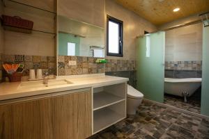 La salle de bains est pourvue d'un lavabo, de toilettes et d'une baignoire. dans l'établissement 123 Hall, à Wujie