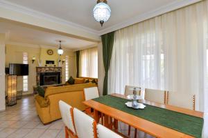 a living room with a dining table and a couch at Kilic- 5 Bedroom Holiday Villa in Hisaronu in Ovacik
