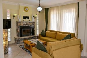 a living room with a couch and a fireplace at Kilic- 5 Bedroom Holiday Villa in Hisaronu in Ovacik