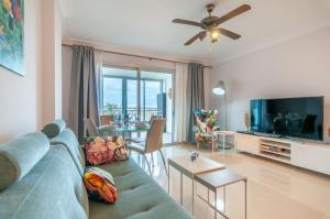 sala de estar con sofá azul y TV en San Remo 1A036 en Palm-mar