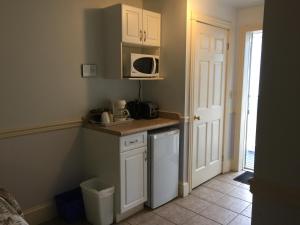 uma pequena cozinha com um lavatório e um micro-ondas em Seawinds Motel & Cottages em Digby