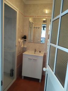 a bathroom with a white sink and a shower at Casa de las Lanzas in Setenil