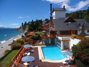 a house with a swimming pool next to a beach at Apart Del Lago in San Carlos de Bariloche