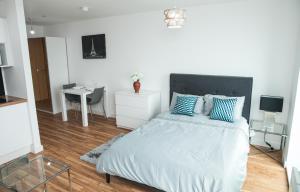 a bedroom with a bed with blue pillows and a desk at Studio Apartments Free street parking subject to availability in Manchester