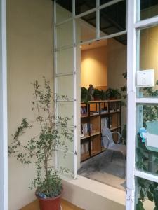 a room with a window and a chair and a book shelf at Right Here Hotel (Dunhuang International Youth Hostel) in Dunhuang