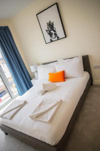 a bedroom with a bed with orange and white pillows at Thames View 2 Bed Apartment With Balcony in London