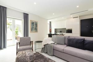 a living room with a couch and a kitchen at Bela Vista Palace Apartments in Cascais