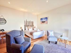 a living room with a bed and a chair at Phoenix Apartments in Lorne