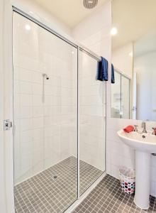 uma casa de banho com um chuveiro e um lavatório. em Phoenix Apartments em Lorne