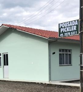 un edificio blanco con un cartel encima en Pousada Pickler, en Urubici