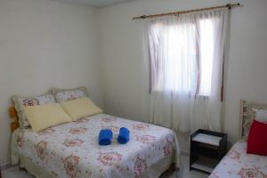 Un dormitorio con una cama con zapatos azules. en Cantinho Do Sossego, en Canela
