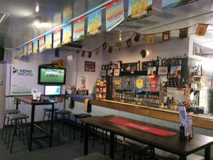 a bar with two tables and a television on the wall at Bluff Hotel in Bluff