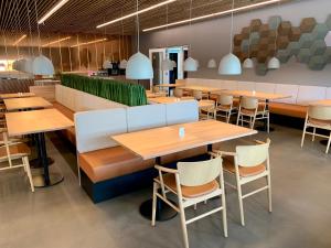 a restaurant with wooden tables and chairs at Hotel DGI-Huset Herning in Herning
