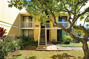 a yellow building with a staircase in front of it at Turtle Bay Sea BreezeNUC 90-TVU-0498 in Kahuku