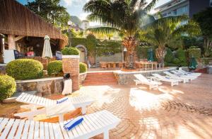 a row of white chairs and tables and palm trees at Beachfront Hotel in Vung Tau