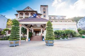 un gran edificio con una torre de reloj delante de él en Beachfront Hotel en Vung Tau