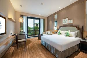 um quarto de hotel com uma cama grande e uma secretária em C&D Resort,Wuyi Mountain em Wuyishan