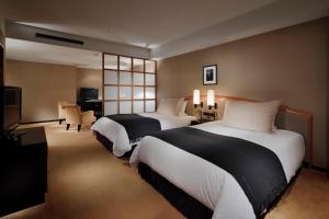 a hotel room with two beds and a television at Hotel Granvia Kyoto in Kyoto