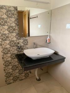 een badkamer met een wastafel en een spiegel bij Gyaslang Guesthouse in Leh