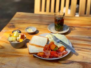 a table with a plate of food and a glass of tea at AMIGO LEH Guesthouse in Leh +12 photos