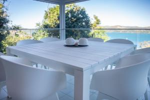 a white table and chairs with a view of the water at Oasis 22 - Hamilton Island in Hamilton Island