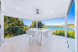a white dining room with a table and chairs at Oasis 22 - Hamilton Island in Hamilton Island