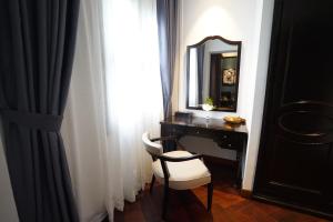 
a room with a chair and a mirror at Hotel Majestic Saigon in Ho Chi Minh City

