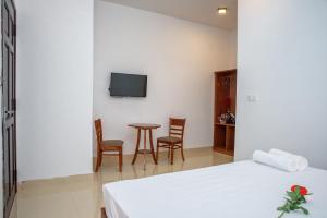a bedroom with a bed and a table with chairs at PaPa Villa Homestay in Hoi An