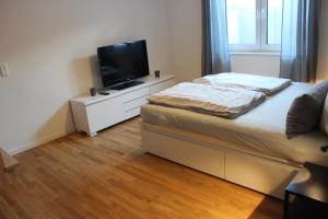 Schlafzimmer mit einem Bett und einem Flachbild-TV in der Unterkunft Ferienwohnung Schmiedeglück in Bad Krozingen