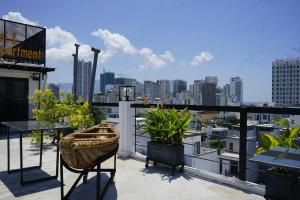 a balcony with plants and a view of a city at Oasis Hotel & Apartment in Da Nang