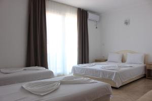 2 bedden in een hotelkamer met een raam bij Presheva Rooms in Ulcinj