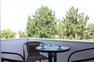 een kleine tafel en stoelen op een balkon met bomen bij Presheva Rooms in Ulcinj