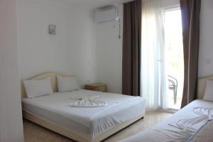 een wit bed in een kamer met een raam bij Presheva Rooms in Ulcinj