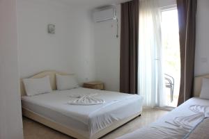 a white bed in a room with a window at Presheva Rooms in Ulcinj