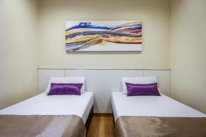 dwa łóżka w pokoju z obrazem na ścianie w obiekcie Hotel 81 Cosy w Singapurze