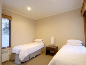 a room with two beds and a window at Ultima Apartments in Mount Hotham
