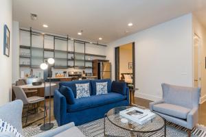 sala de estar con sofá azul y sillas y cocina en Mint House at The Reserve - Nashville, en Nashville