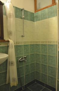 a bathroom with a shower with green tiles at Homeros Pension & Guesthouse in Selcuk