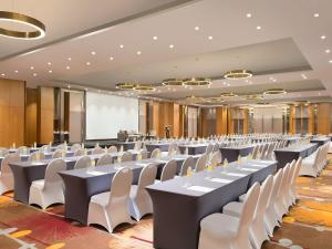 un gran salón de banquetes con mesas y sillas blancas en Holiday Inn & Suites Jakarta Gajah Mada, an IHG Hotel en Yakarta