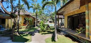 a courtyard of a house with palm trees and a building at Teratai Boutique Resort in Amed