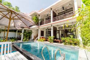 a villa with a swimming pool and a house at An Bang Coco Villa in Hoi An