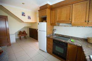 a kitchen with wooden cabinets and a white refrigerator at Casa Rural El Lio in Ruidera