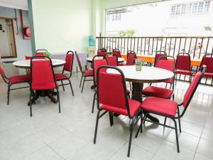 a dining room with tables and red chairs at Ridel Boutique Hotel in Wakaf Che Yeh