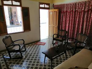 a living room with chairs and a couch and a table at Hostal Trista 117 in Santa Clara