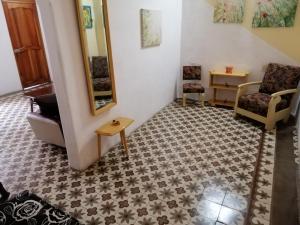 a living room with a tile floor and a mirror at Hostal Trista 117 in Santa Clara