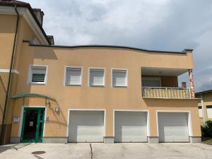 a building with four garage doors in front of it at Apartment Katharina in Klagenfurt